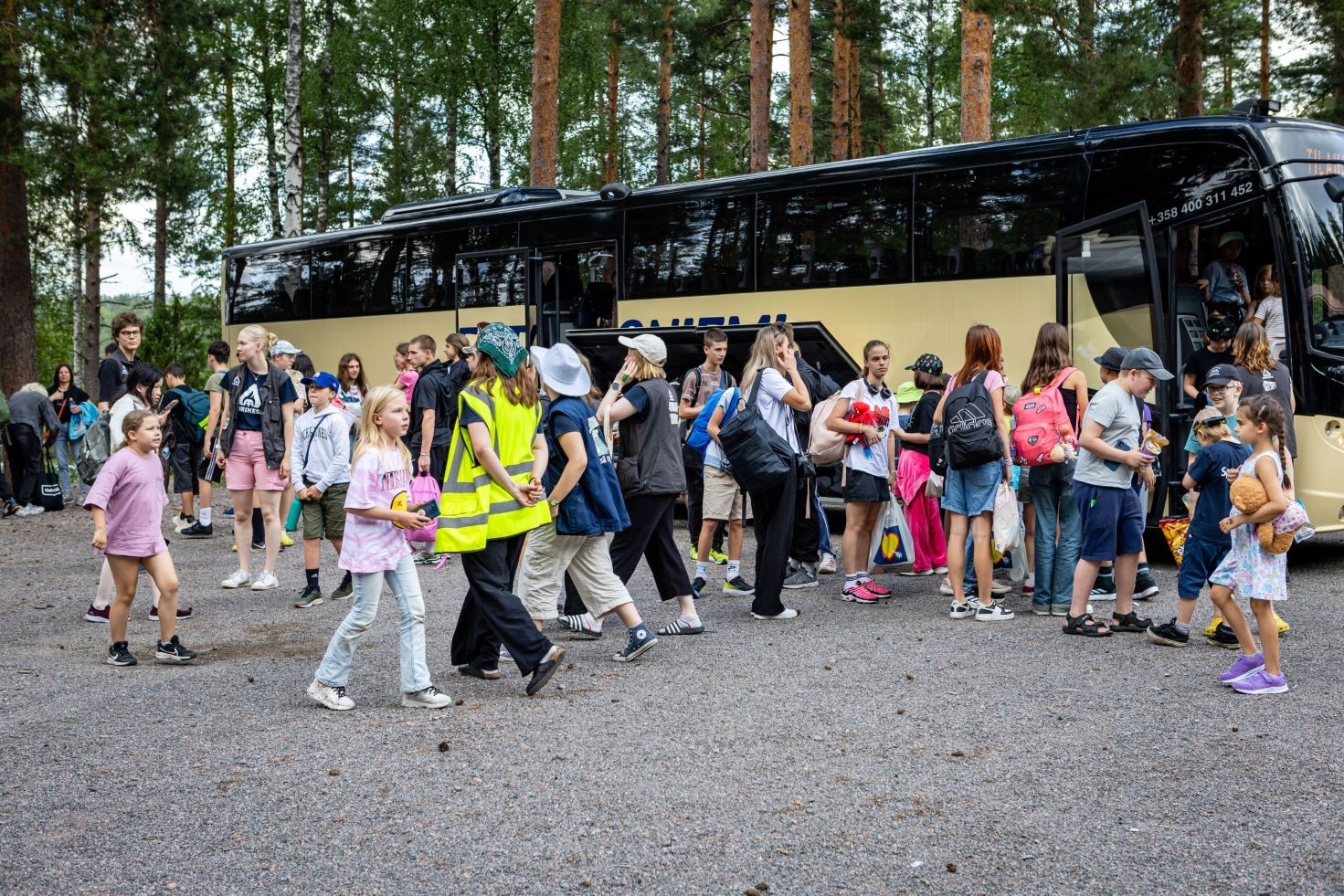 Lapsia ja nuoria bussin edessä saapumassa Kiljavalle